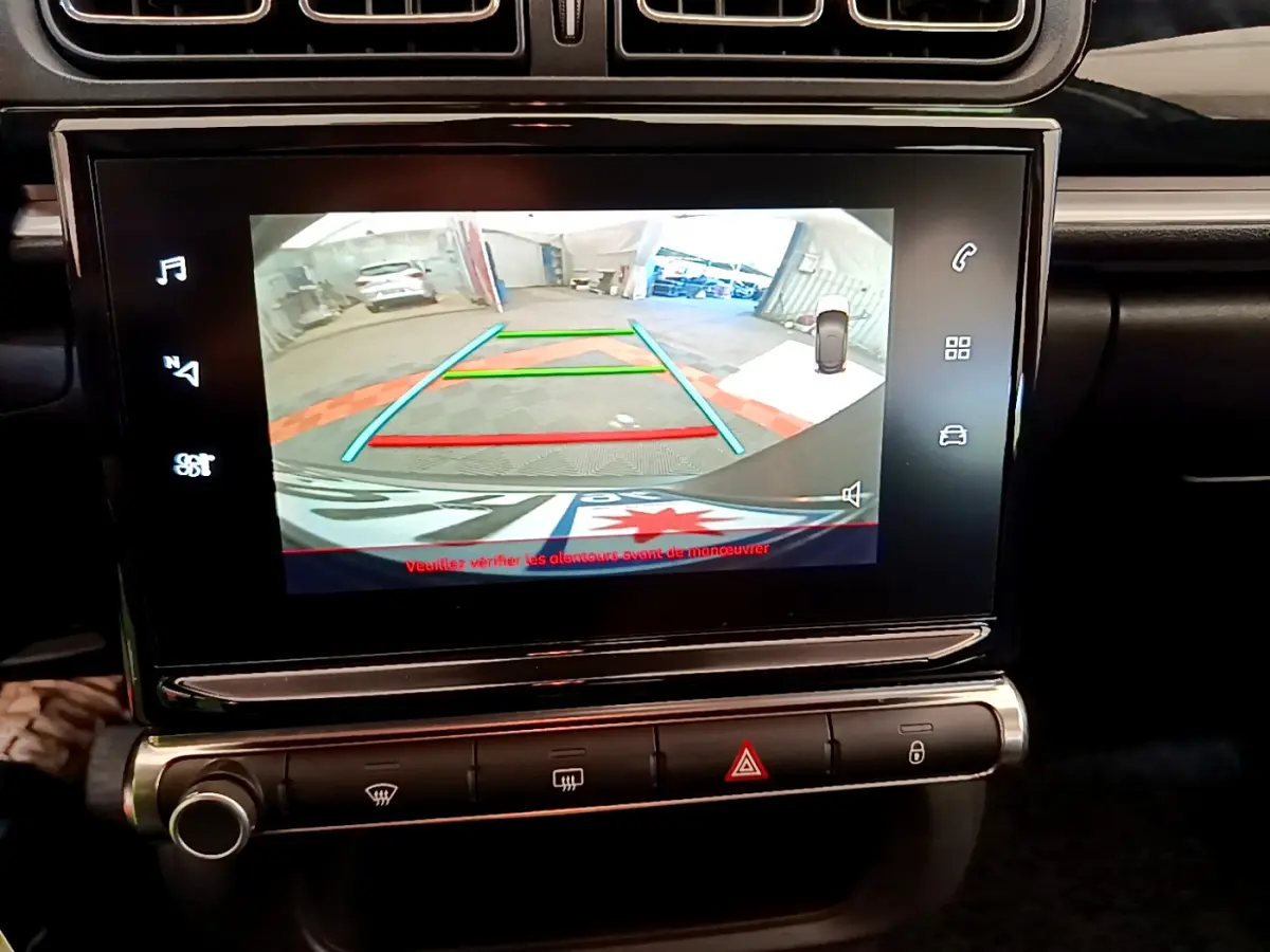 Écran tactile central de la Citroën C3 gris foncé montrant la caméra de recul avec lignes de guidage colorées.