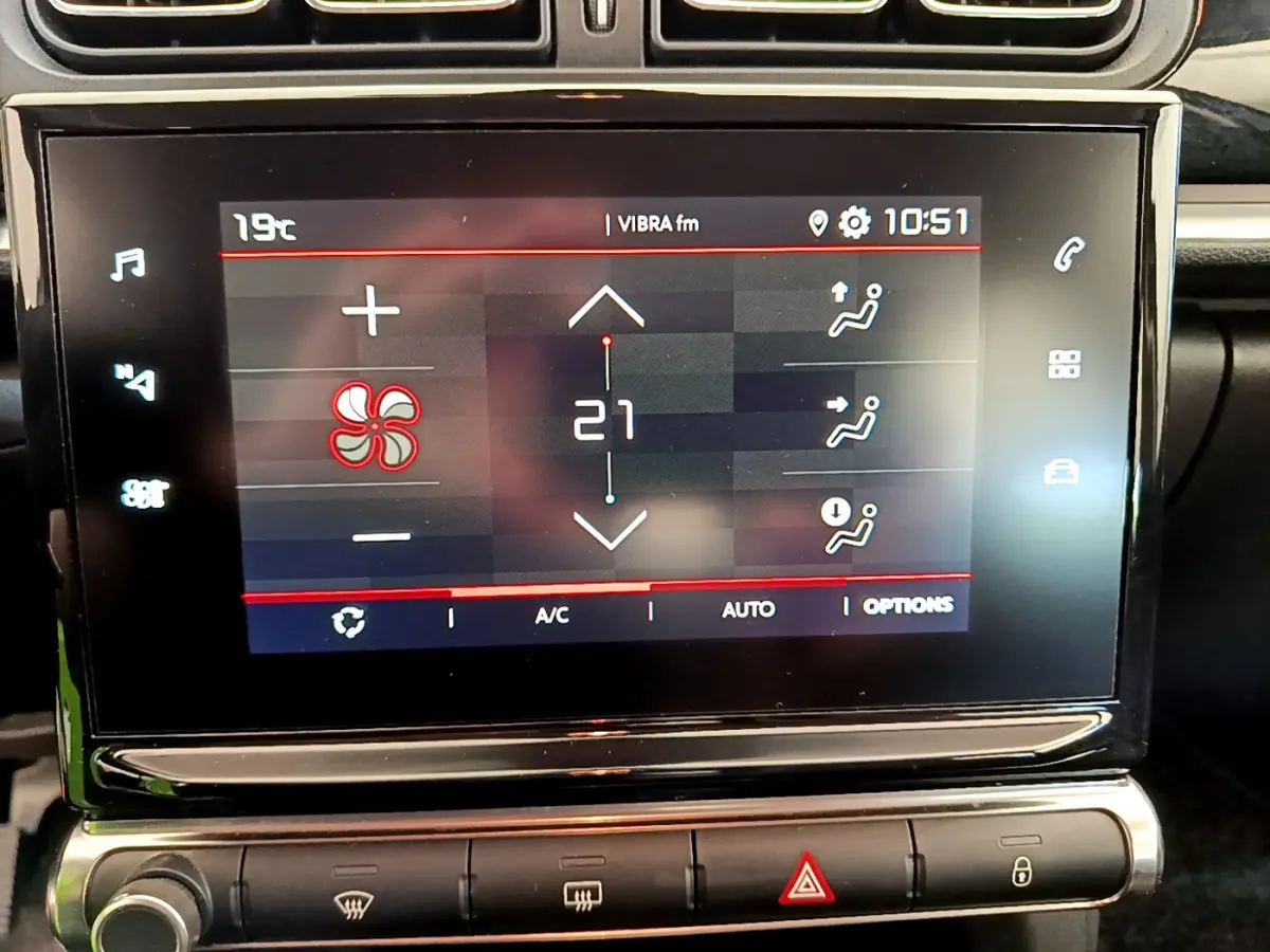 Écran tactile central de la Citroën C3 gris foncé 2019 affichant la climatisation à 21°C en gros plan.