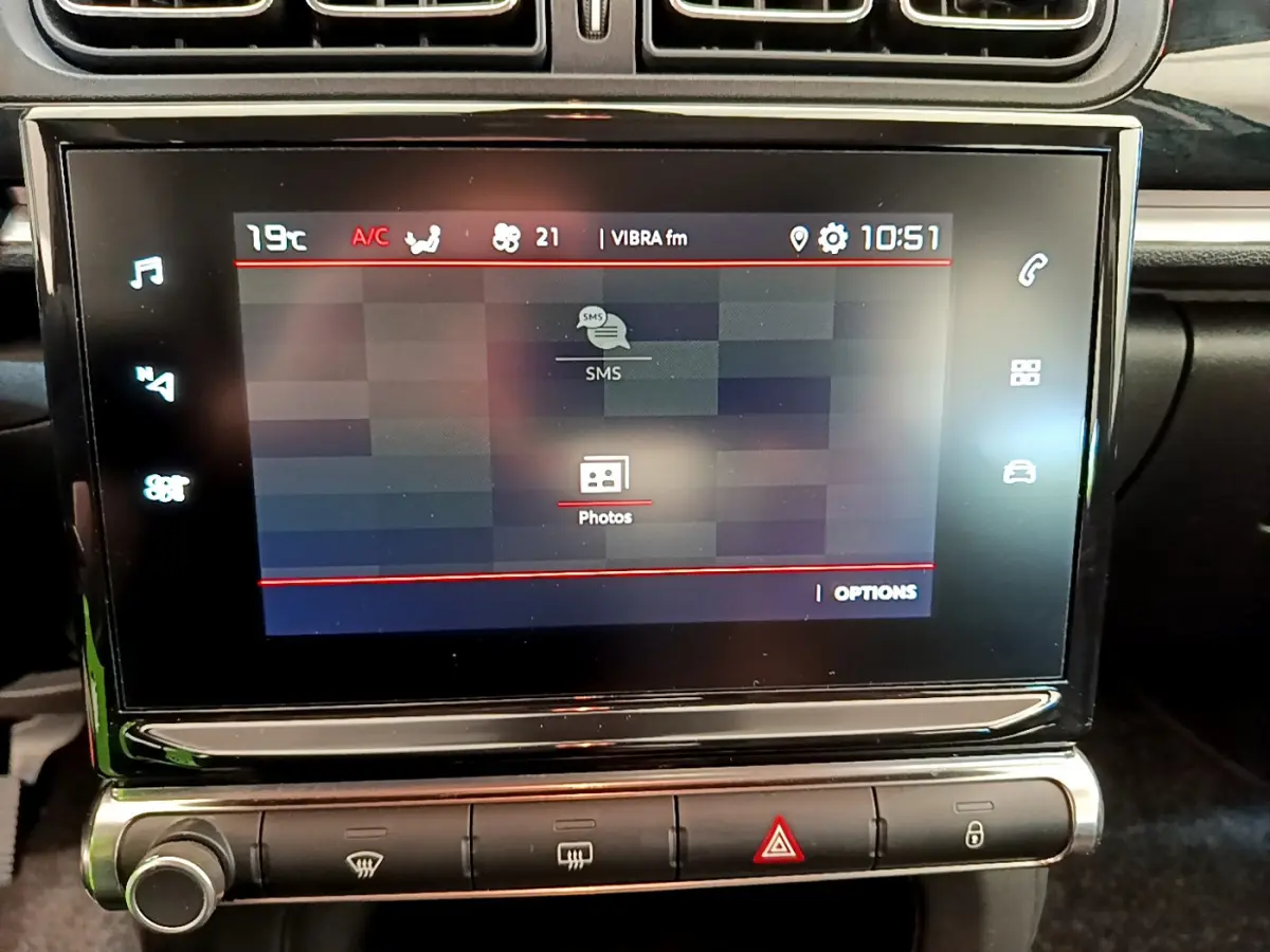 Écran tactile central de 7 pouces affichant des options multimédias dans une Citroën C3 gris foncé, vue intérieure rapprochée.
