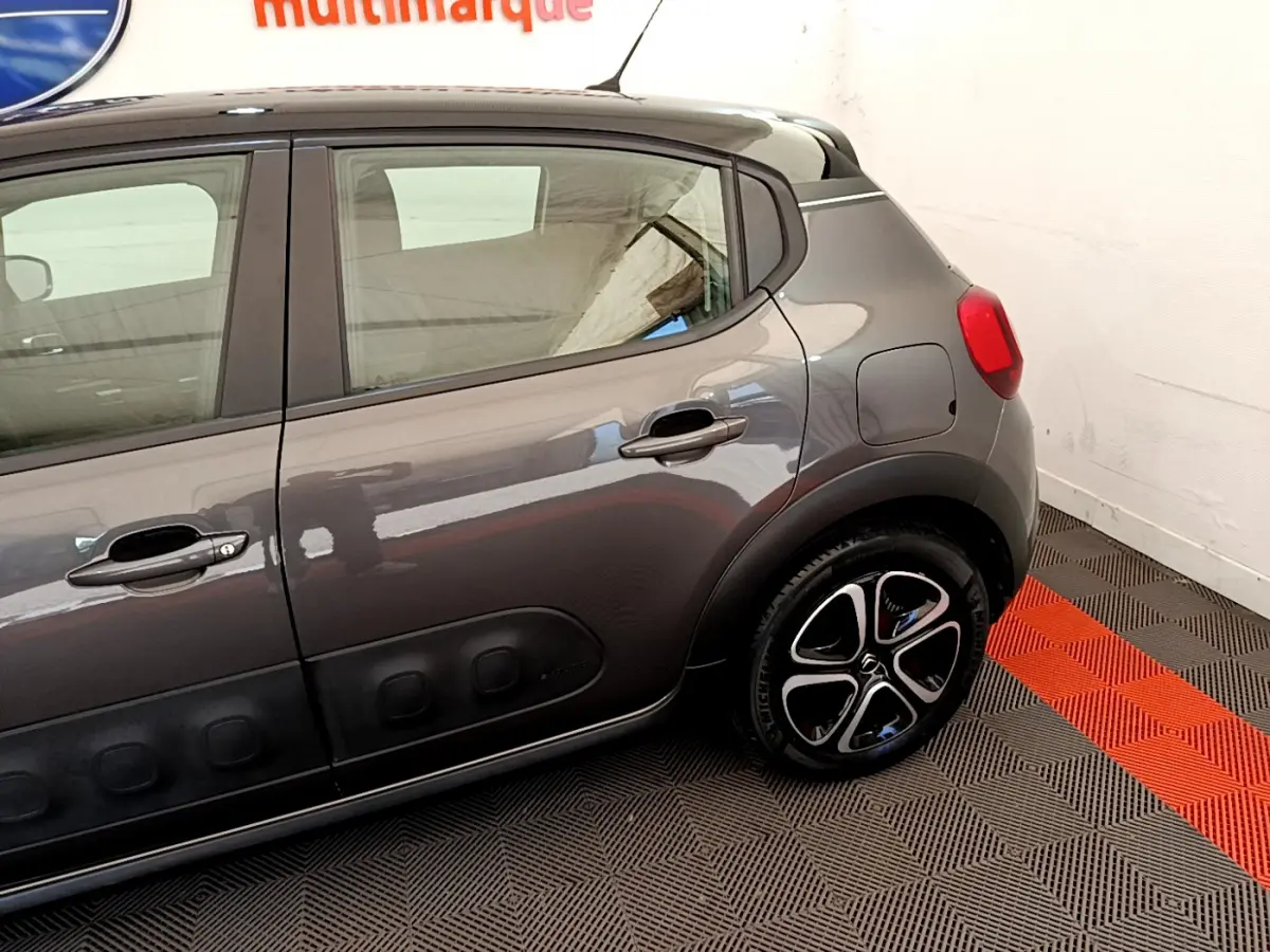 Vue latérale droite d'une Citroën C3 gris foncé avec jantes noires et détails Airbump sur porte arrière.