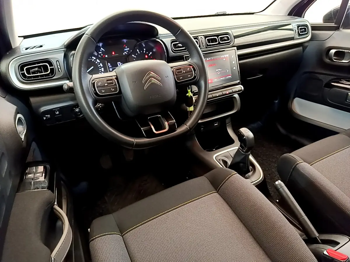 Intérieur de la Citroën C3 2019, vue du poste de conduite avec volant cuir et écran tactile central.