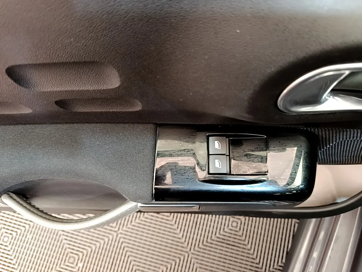 Gros plan sur la commande des vitres électriques côté conducteur d'une Citroën C3 gris foncé, finition Shine 2019.