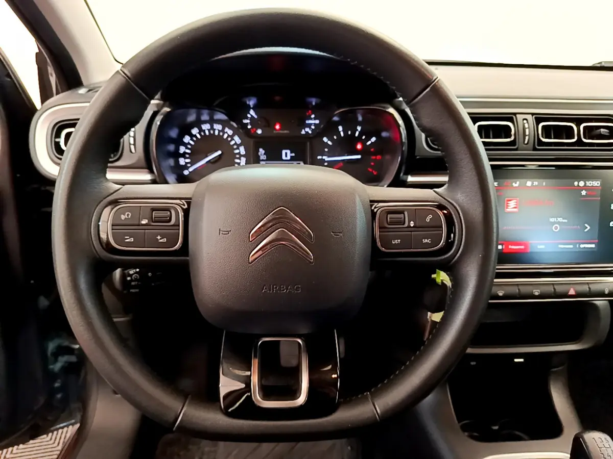 Vue rapprochée du volant cuir noir de la Citroën C3 2019 avec tableau de bord et écran tactile central allumé.
