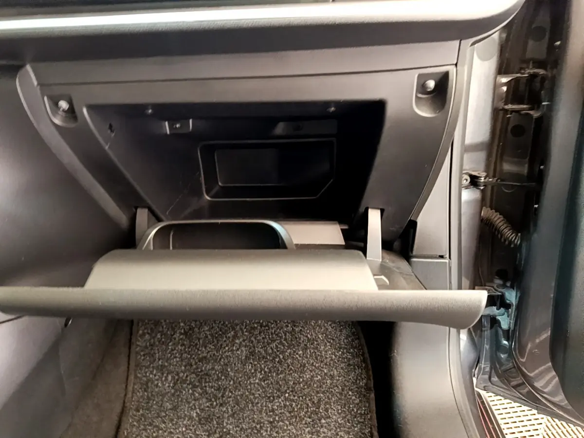 Gros plan sur la boîte à gants ouverte côté passager d'une Citroën C3 gris foncé 2019 PureTech Shine.