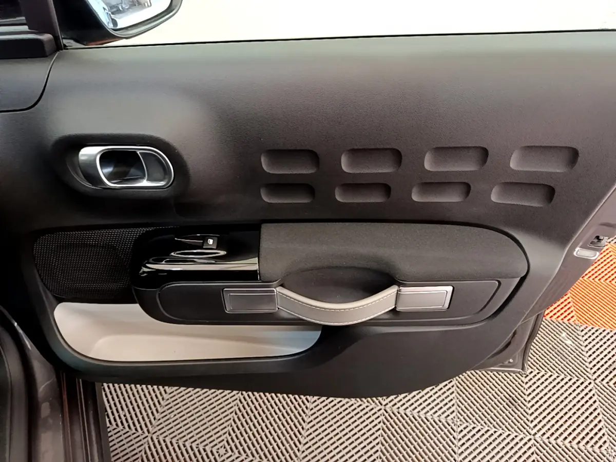 Détail de la porte côté conducteur de la Citroën C3 2019 gris foncé avec poignée et commandes de vitre.