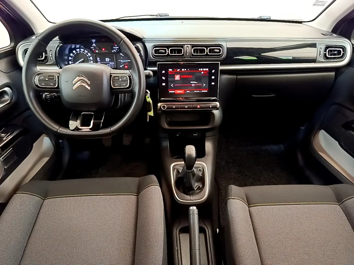 Intérieur Citroën C3 2019 vu de face, tableau de bord noir avec écran tactile central et volant cuir multifonctions.