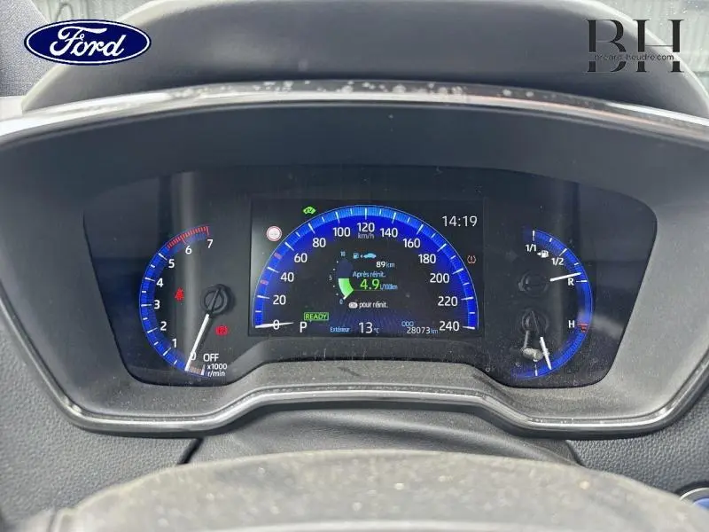 Tableau de bord numérique de Toyota Corolla gris Manhattan, affichage vitesse et autonomie en vue frontale rapprochée.