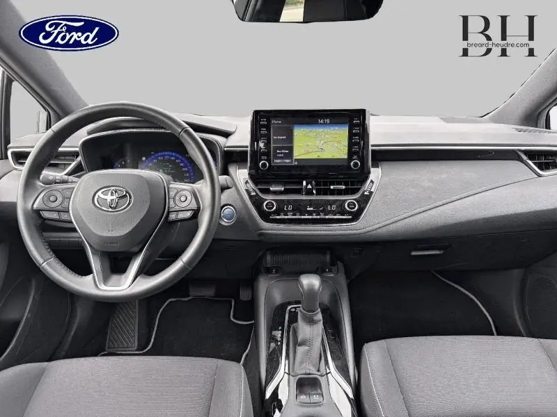 Vue intérieure avant de la Toyota Corolla 122h Dynamic Business 2020, tableau de bord avec écran tactile et volant multifonction.