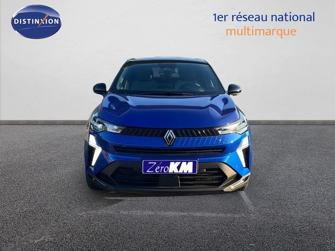 Vue frontale du Renault Captur E-Tech hybride 2025 en bleu Iron Metal avec toit noir et feux LED allumés.