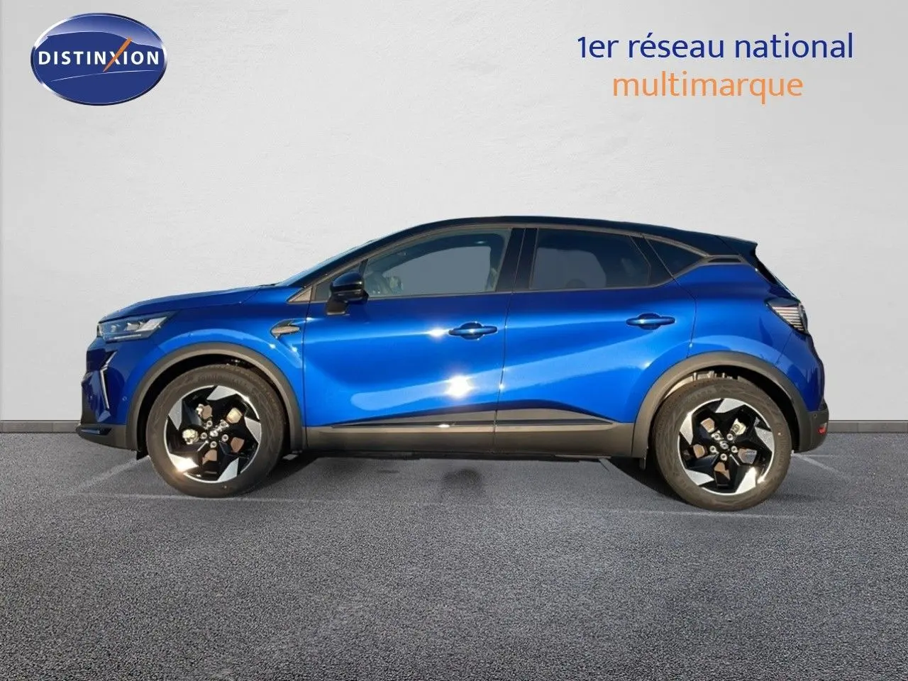 Profil côté gauche d'un Renault Captur E-Tech hybride 2025 bleu Iron avec toit noir et jantes noires distinctives.