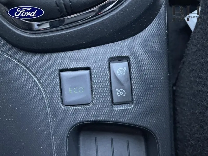 Gros plan sur les boutons de commande ECO et régulateur de vitesse dans un Renault Captur beige 2015.