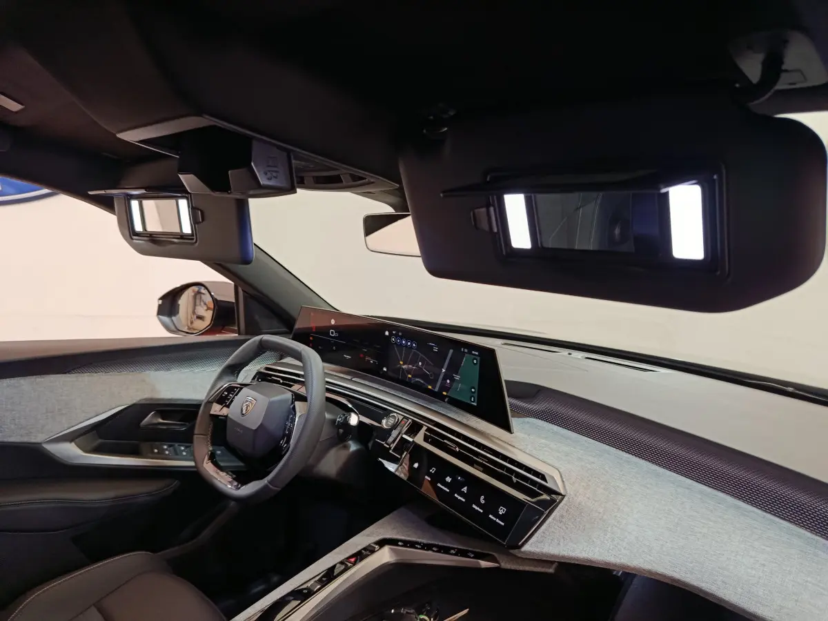 Intérieur du Peugeot 3008 2025 noir, vue côté conducteur sur tableau de bord et écran tactile panoramique.