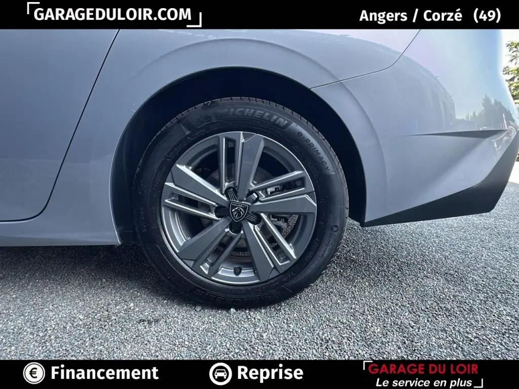 Gros plan sur la roue arrière droite gris clair d'une Peugeot 308 2023 avec jante alliage au design moderne.