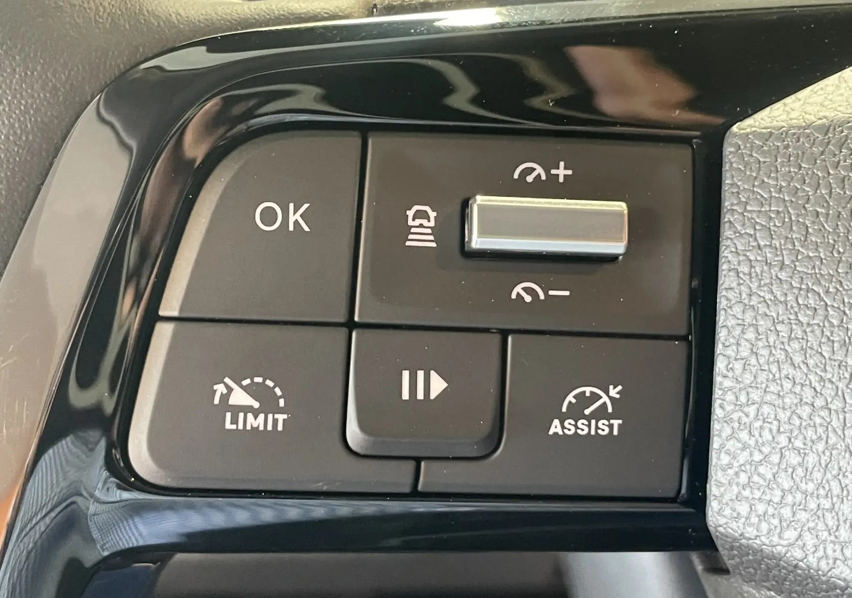 Gros plan sur les commandes noires du volant du Peugeot Traveller 2026, avec régulateur de vitesse et assistant.