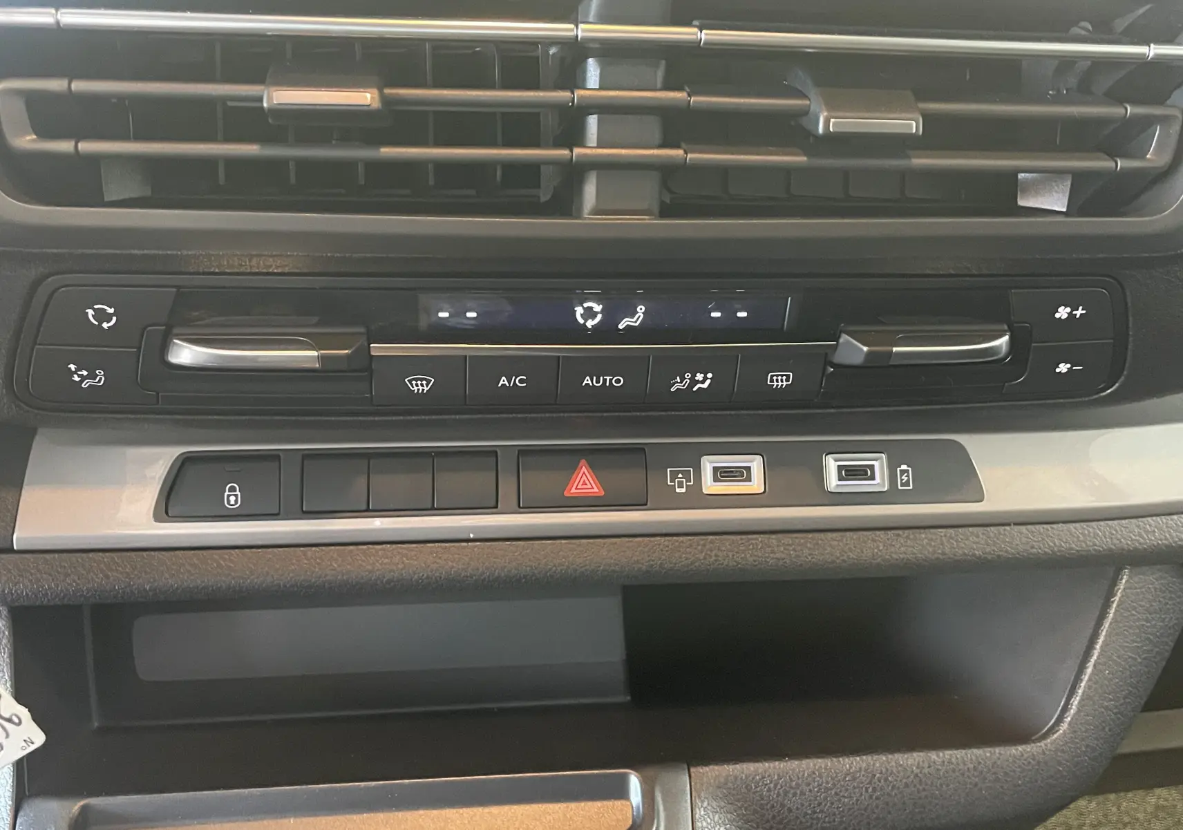 Vue rapprochée de la console centrale du Peugeot Traveller 2026, montrant les commandes de climatisation et ports USB.