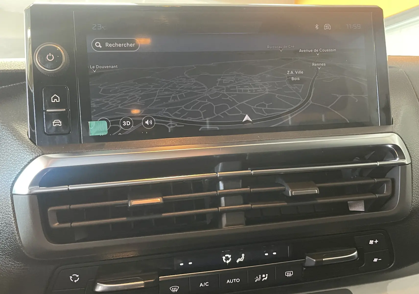 Vue rapprochée de l’écran tactile central et des aérateurs du tableau de bord du Peugeot Traveller noir, affichant la navigation.