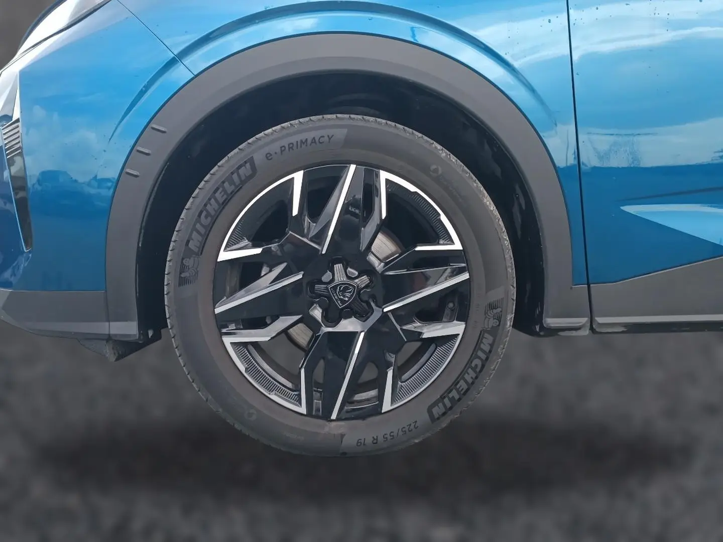 Gros plan sur la roue avant droite du Peugeot 3008 bleu 2025 avec jante alu noire et argentée.
