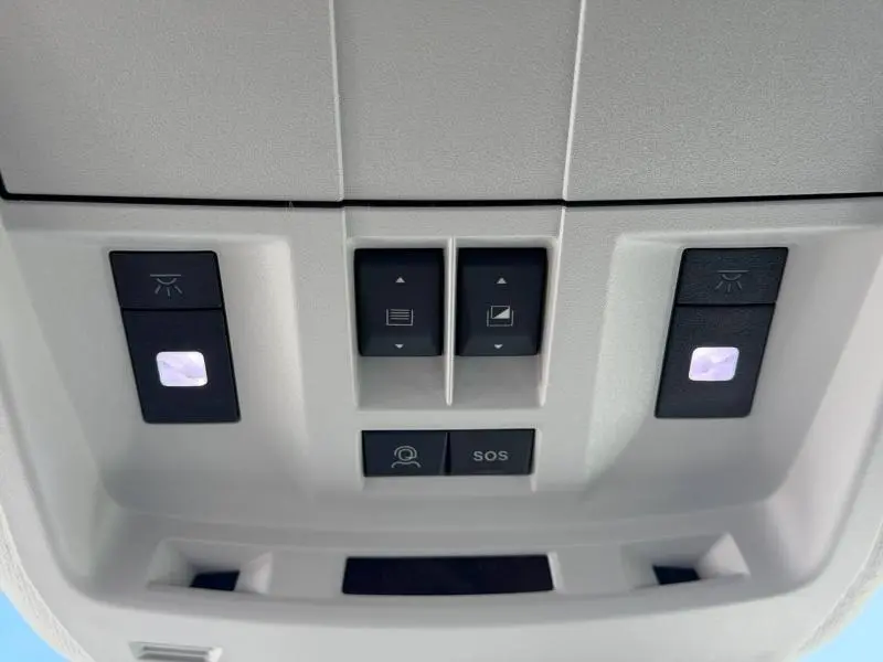 Vue rapprochée du panneau de commandes de toit intérieur avec boutons d’éclairage et SOS du Citroën C5 Aircross noir Perla Nera.