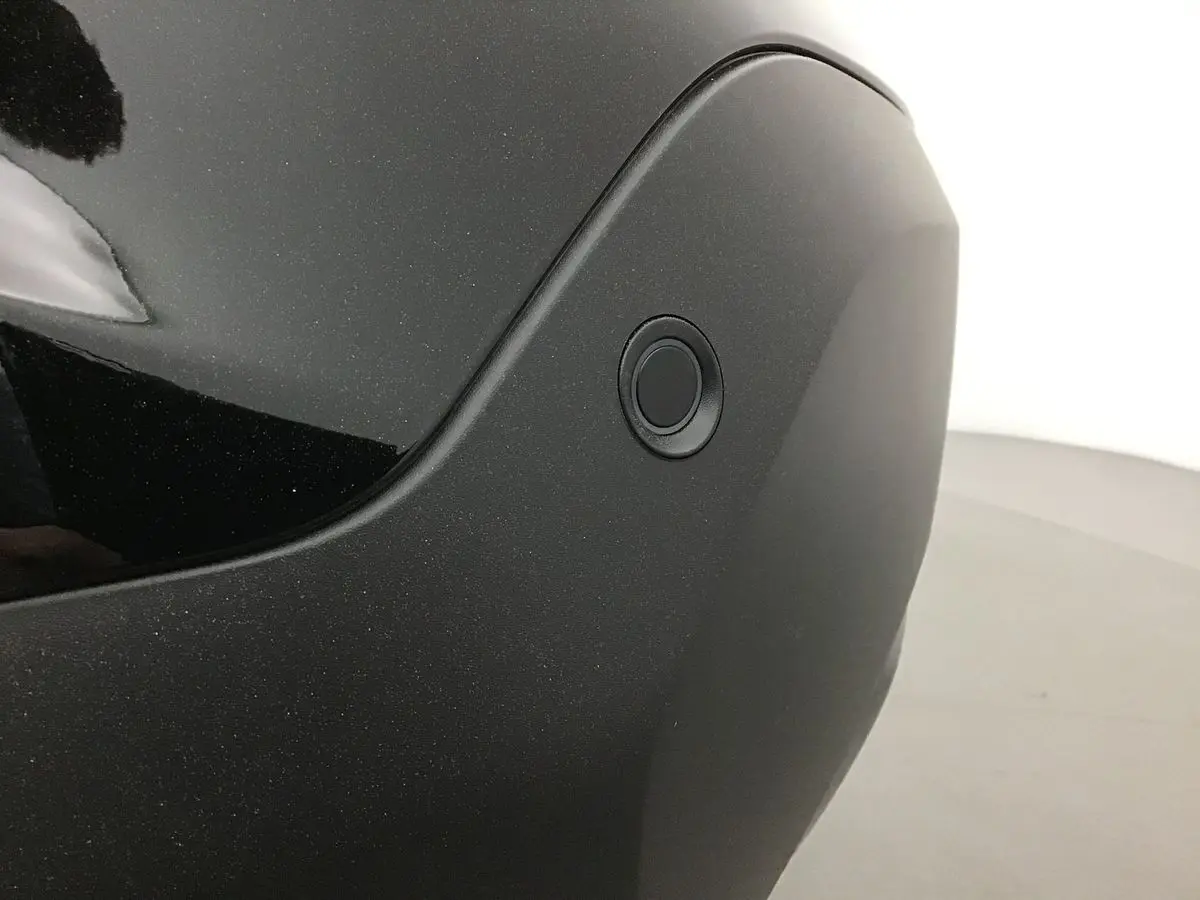 Gros plan sur le capteur de stationnement arrière du pare-chocs noir d'une Citroën C4 2022 finition Feel Pack.