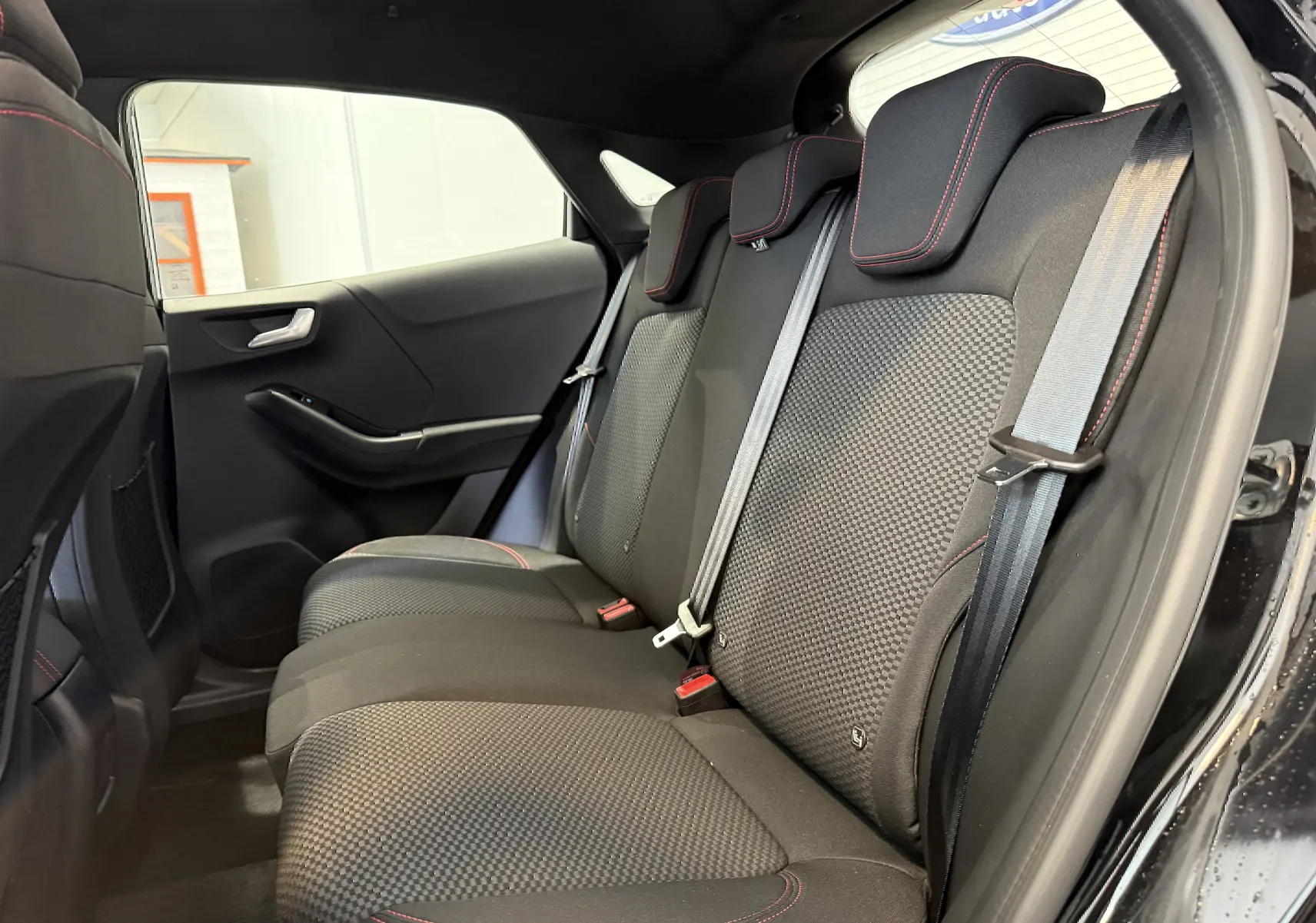 Vue latérale droite de la banquette arrière noire avec surpiqûres rouges du Ford Puma 2022, version ST-Line.