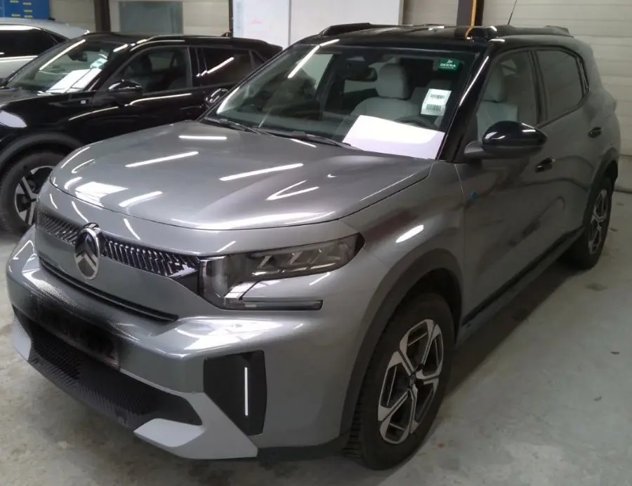 Citroën C3 Aircross Electric gris mercury avec toit noir, vue 3/4 avant en intérieur showroom.