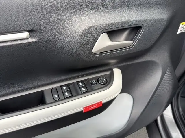 Gros plan sur la porte côté conducteur du Citroën C3 Aircross gris mercury, avec commandes électriques et poignée argentée.