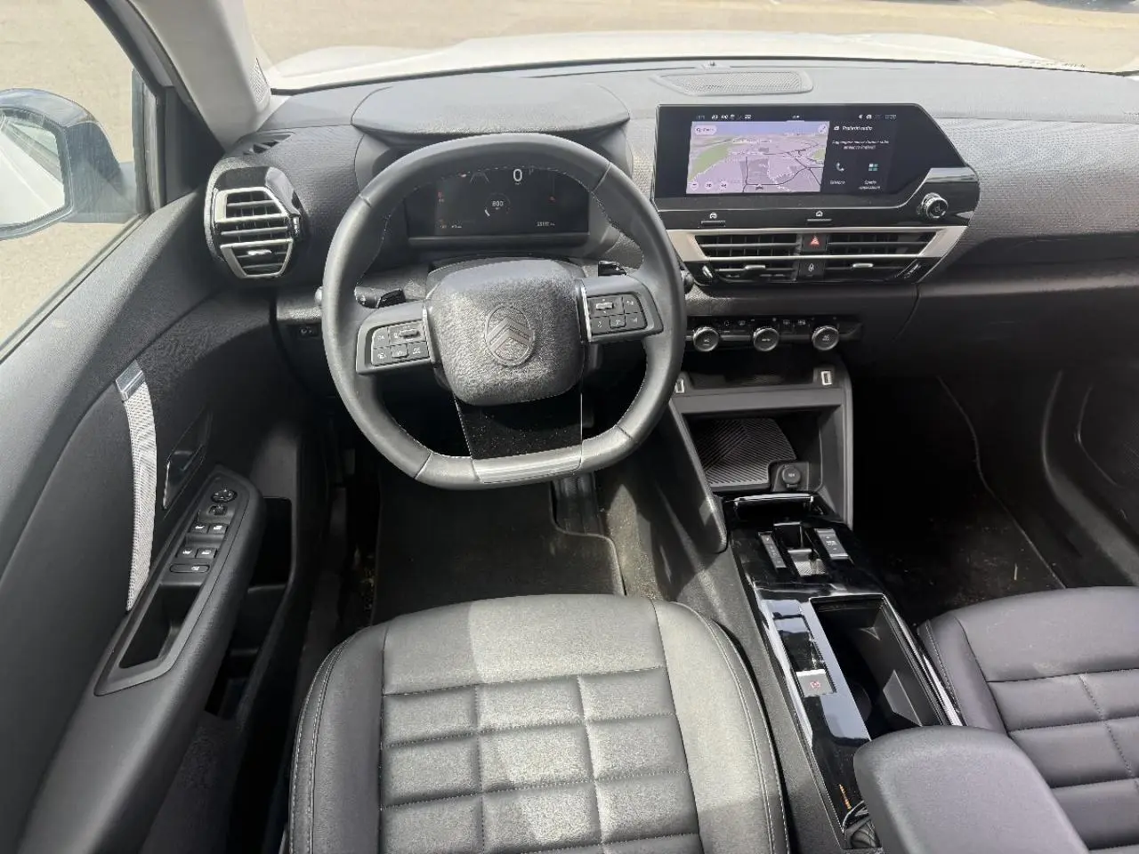 Vue intérieure du poste de conduite de la Citroën C4 2025, avec volant multifonction et écran tactile central.