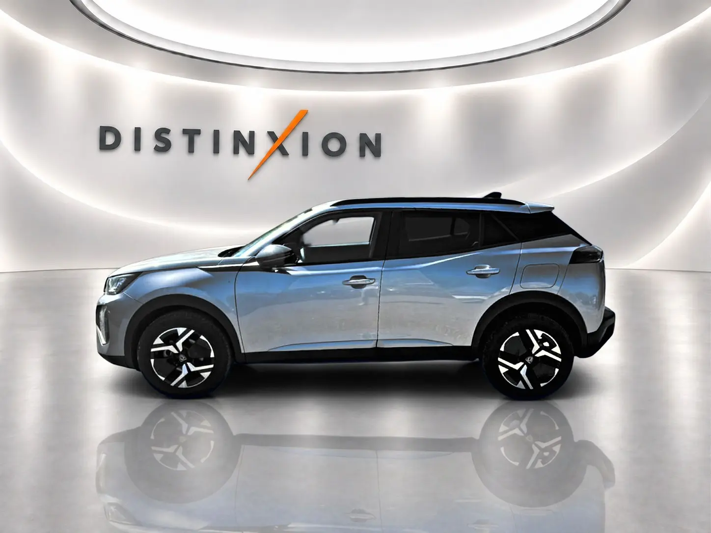 Peugeot 2008 gris artense en profil côté gauche, avec jantes alu et toit noir dans un showroom lumineux.