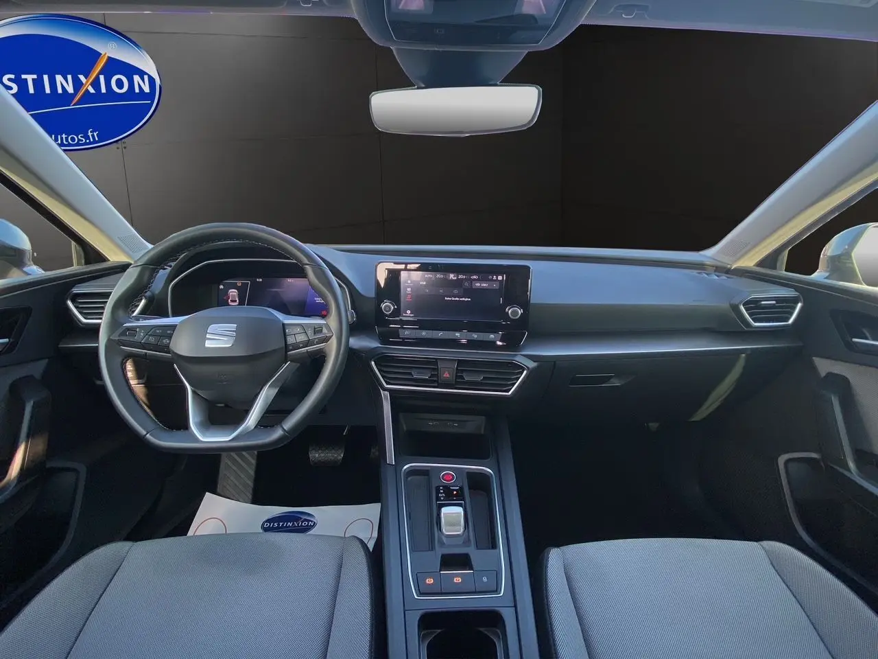 Vue intérieure frontale du tableau de bord et volant cuir multifonctions de la SEAT Leon IV gris Magnetic 2024.