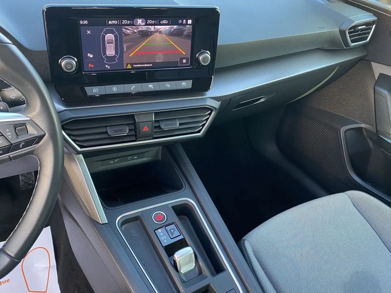 Vue intérieure de la SEAT Leon 2024 côté passager, avec écran tactile affichant la caméra de recul et console centrale moderne.