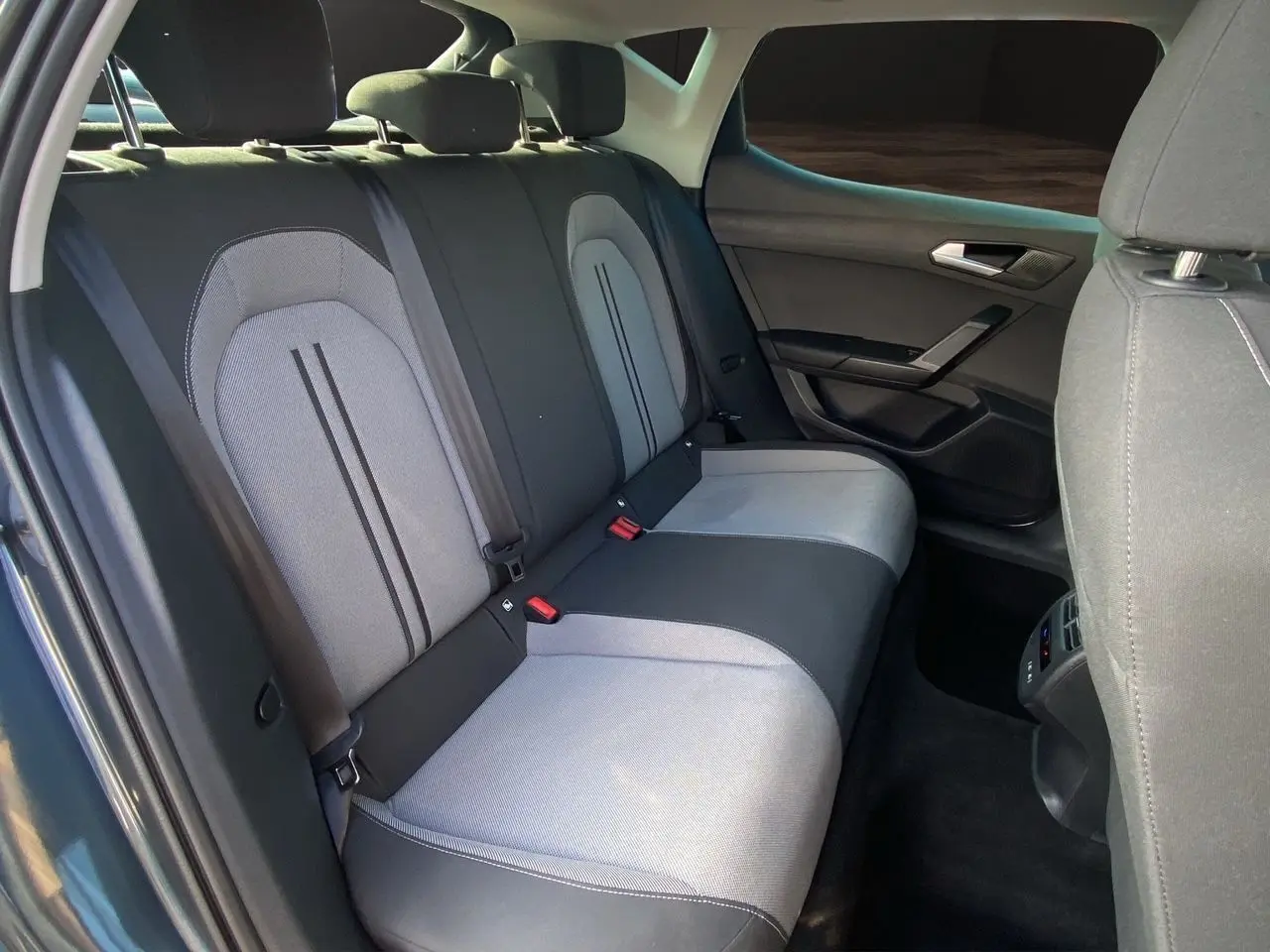 Vue intérieure sur les sièges arrière en tissu noir et gris clair d'une SEAT LEON IV 2024, côté droit ouvert.