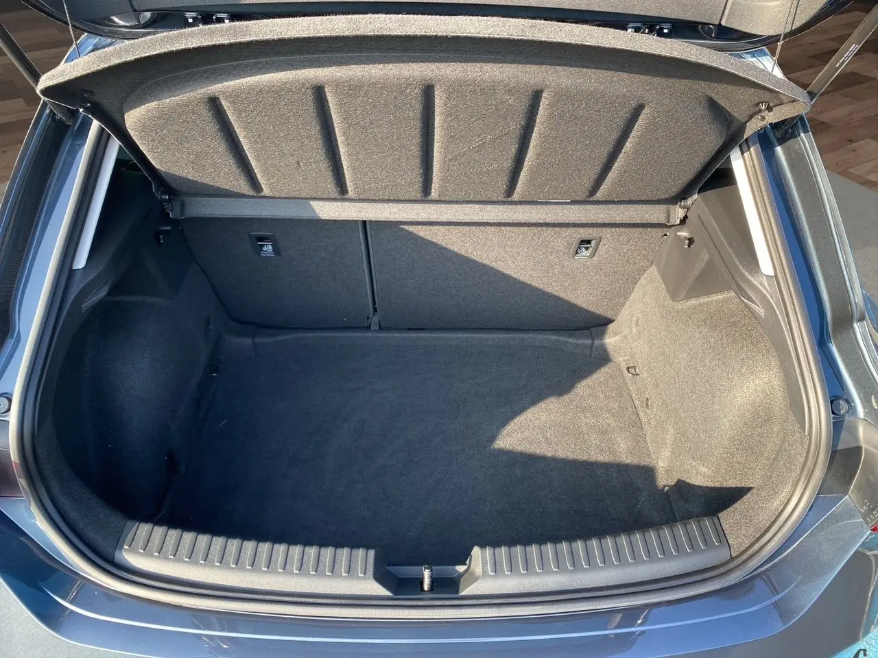 Coffre ouvert vu de dessus du SEAT Leon IV gris magnetic, montrant un espace de chargement propre et spacieux.