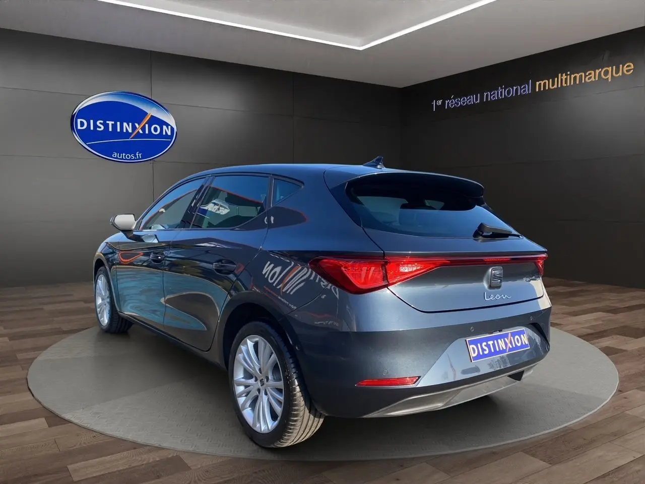 Vue 3/4 arrière droite d'une SEAT Leon gris magnetic 2024 avec jantes alu 17 pouces et vitres surteintées.