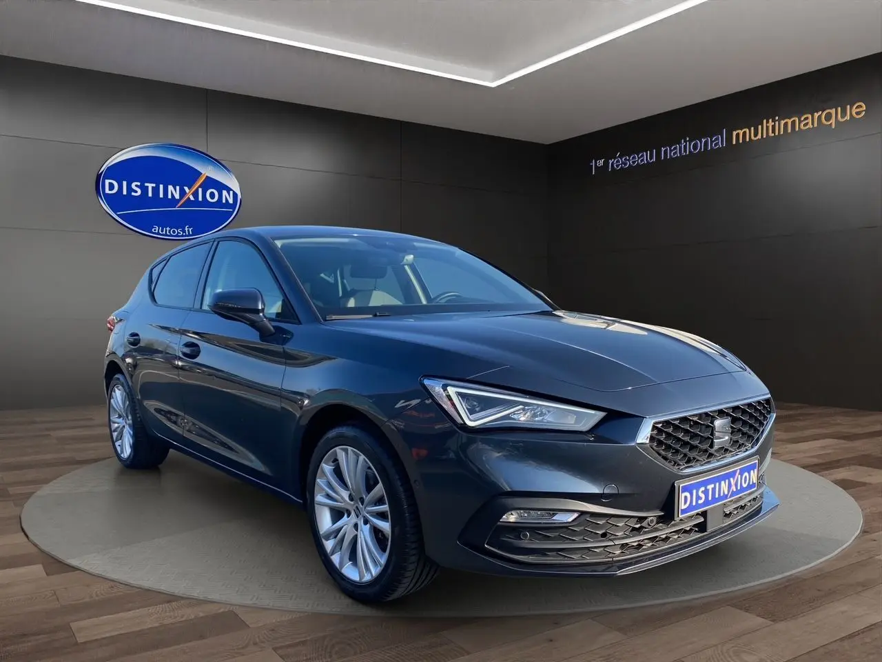 SEAT Leon IV gris Magnetic vue 3/4 avant droit, avec jantes alu 17 pouces et phares full LED allumés.