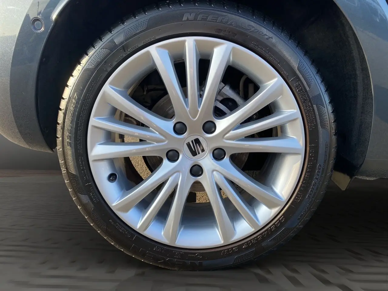 Gros plan sur la jante alu 17 pouces argentée avec logo SEAT, montée sur une SEAT Leon gris magnetic.