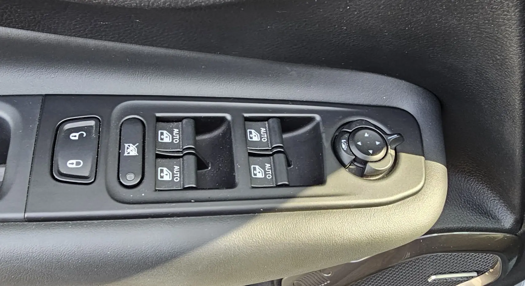 Gros plan sur les commandes de lève-vitres et réglage des rétroviseurs côté conducteur d'un Jeep Renegade Sting Gray 2020.