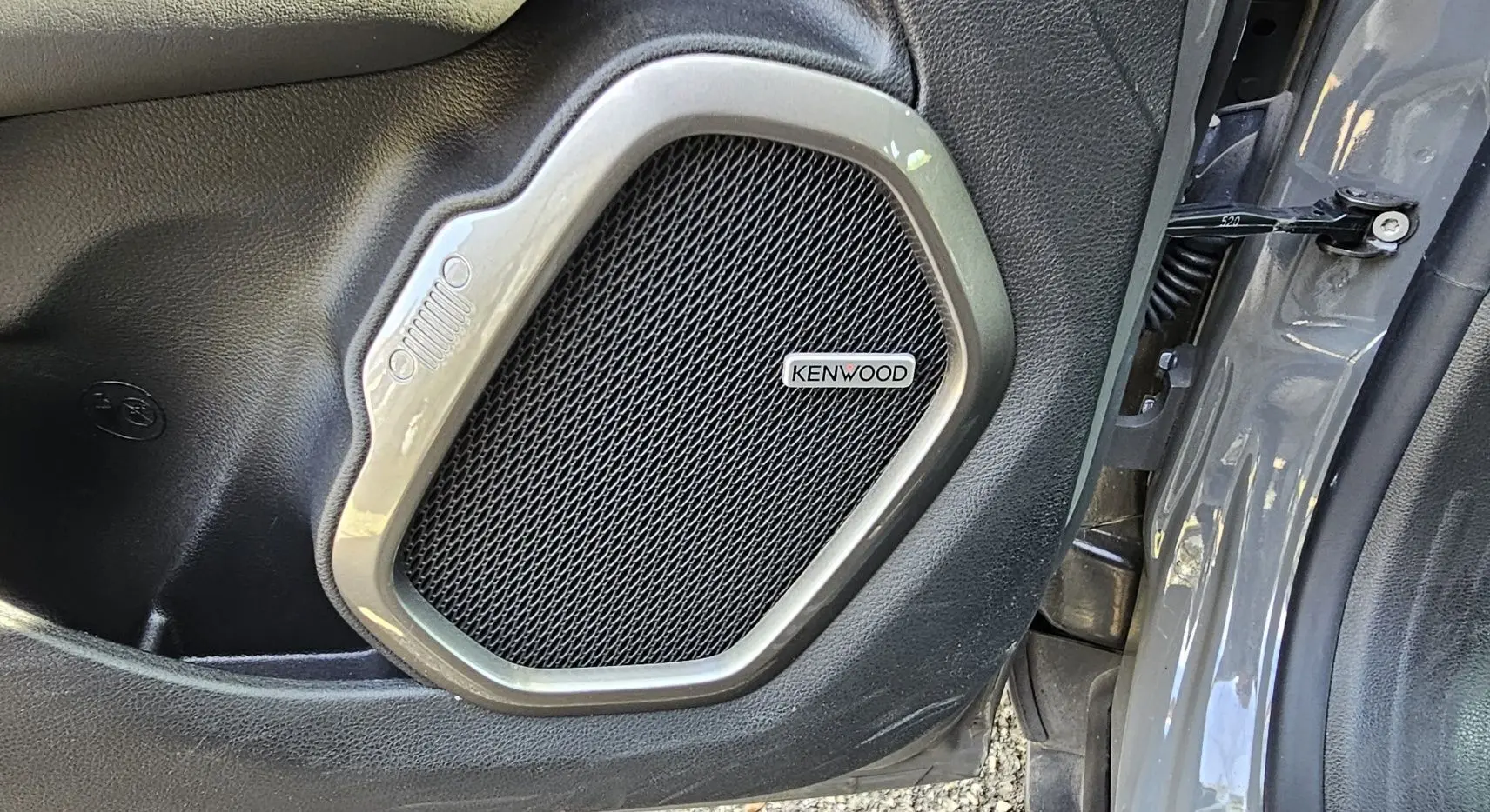 Gros plan sur l'enceinte Kenwood intégrée à la porte côté gauche d'un Jeep Renegade Sting Gray 2020.