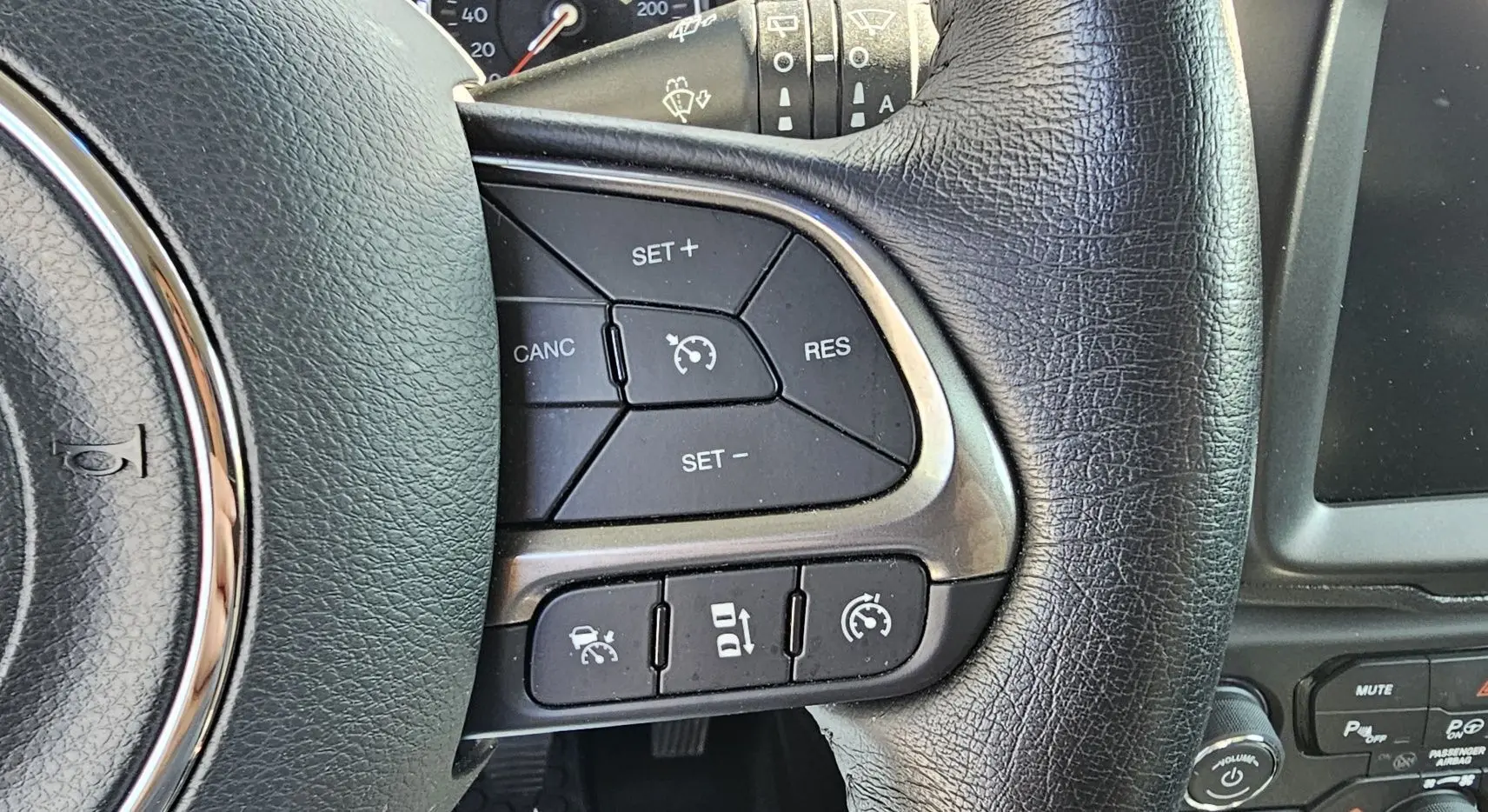 Gros plan sur les commandes de régulateur de vitesse au volant cuir noir du Jeep Renegade Sting Gray 2020.