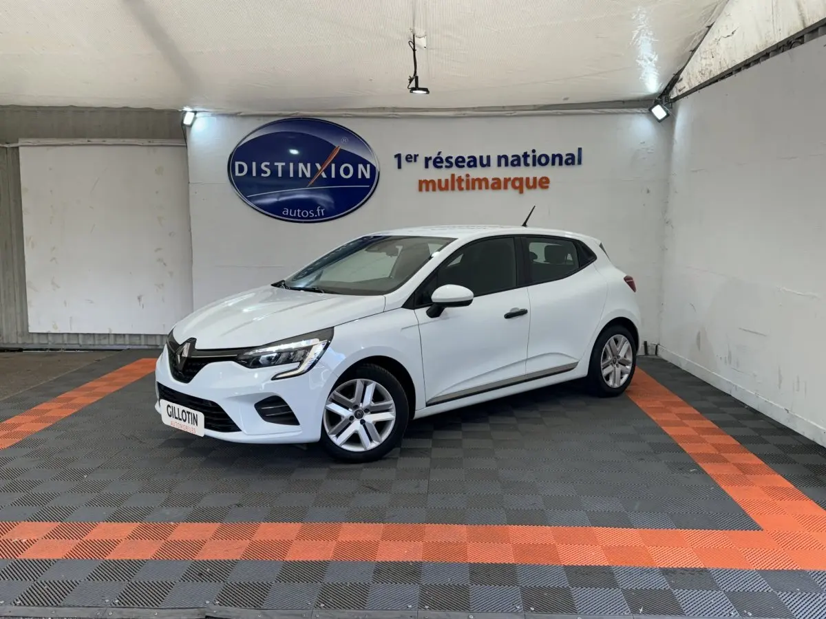 Renault Clio Business blanche vue 3/4 avant droit dans un showroom avec sol gris et bandes orange.