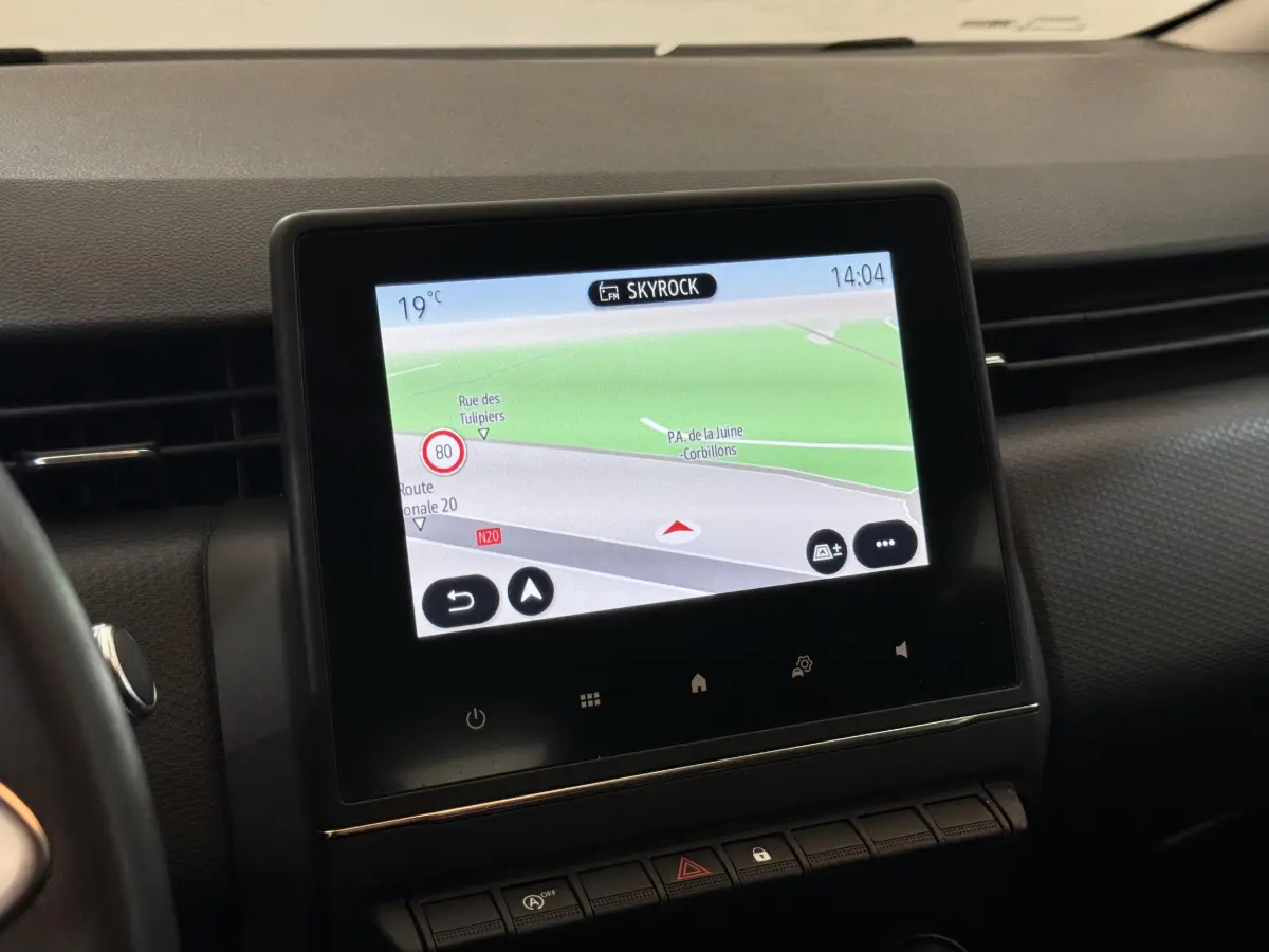 Écran tactile central affichant la navigation dans l'habitacle noir de la Renault Clio Business blanche, vue de face.