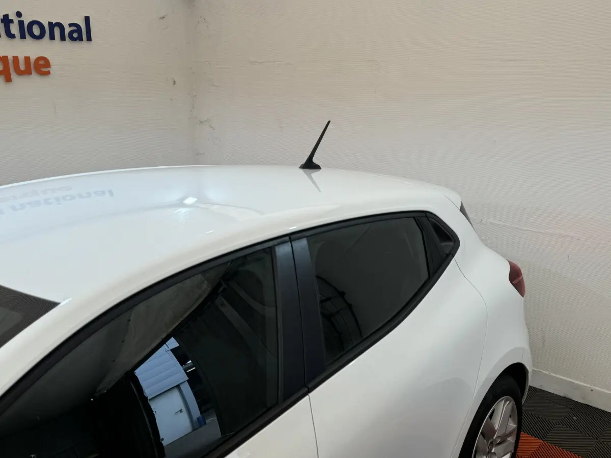 Vue arrière côté droit d'une Renault Clio Business blanche avec vitres teintées et antenne sur le toit.