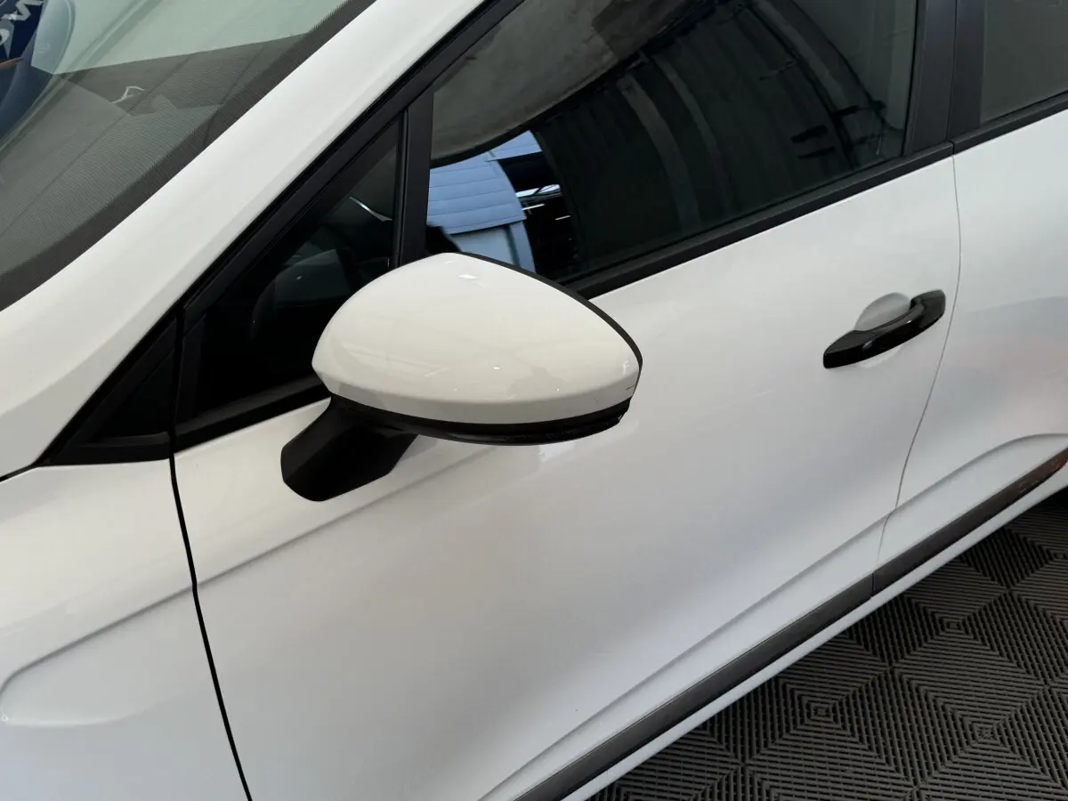 Rétroviseur côté conducteur blanc de la Renault Clio Business SCe 65 vue de profil gauche sur fond intérieur.