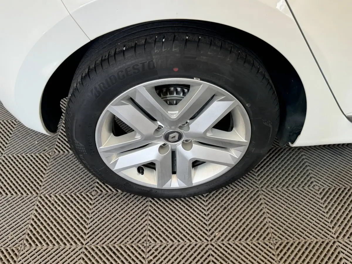 Gros plan sur la roue arrière droite d'une Renault Clio Business blanche, avec jante en alliage et pneu Bridgestone.