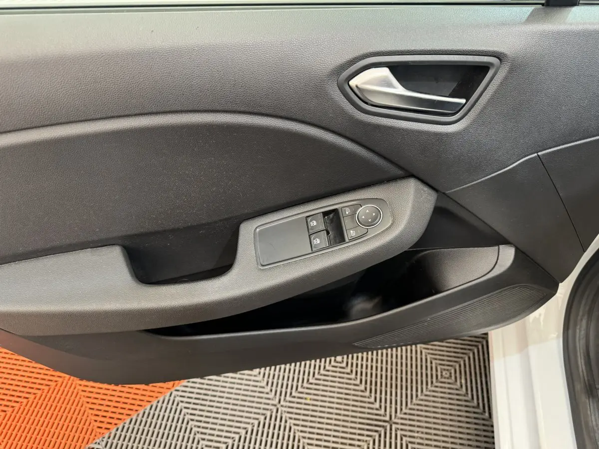Porte intérieure côté conducteur de Renault Clio Business blanche, avec commandes électriques des vitres et poignée argentée.