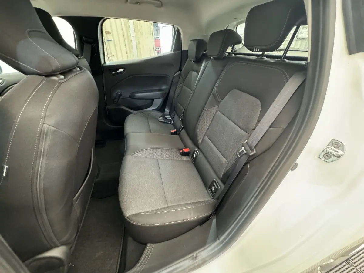 Vue côté gauche des sièges arrière gris foncé de la Renault Clio Business blanche avec porte ouverte.