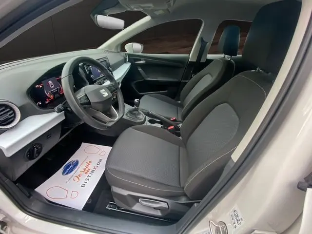 Vue intérieure côté conducteur de la SEAT IBIZA 2023 blanche, avec tableau de bord digital et boîte manuelle.