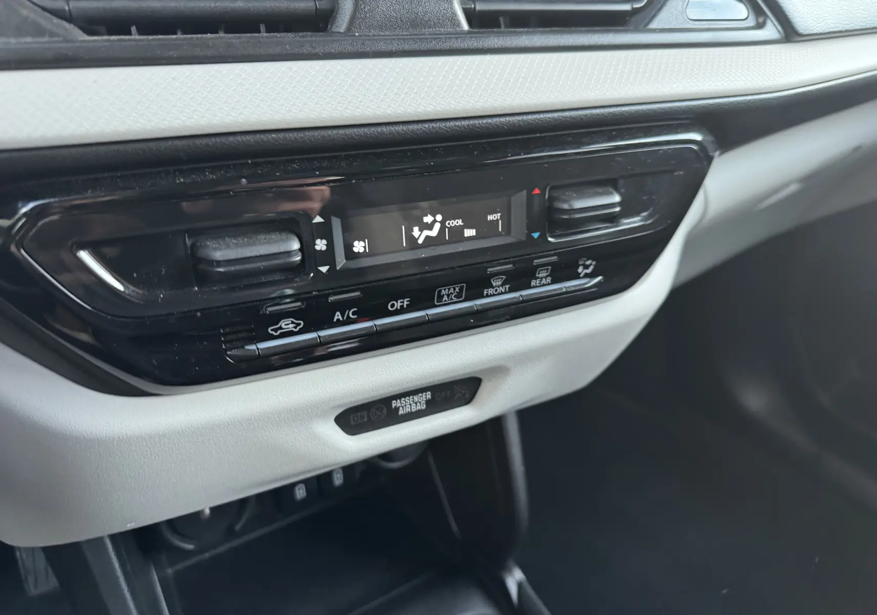 Détail de la console centrale avec commandes de climatisation digitale sur Suzuki Swift blanc 2025.