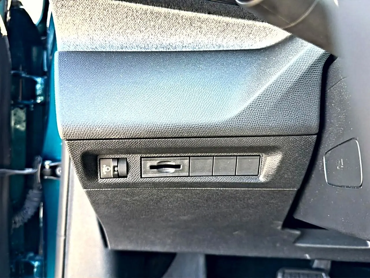 Vue rapprochée côté gauche du tableau de bord noir avec commandes d'éclairage sur Peugeot 408 bleu 2025 Hybrid 145 allure.