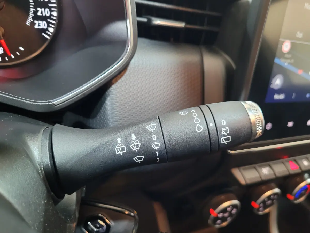 Gros plan sur la commande des essuie-glaces du tableau de bord d'une Renault Clio Business blanche de 2021.