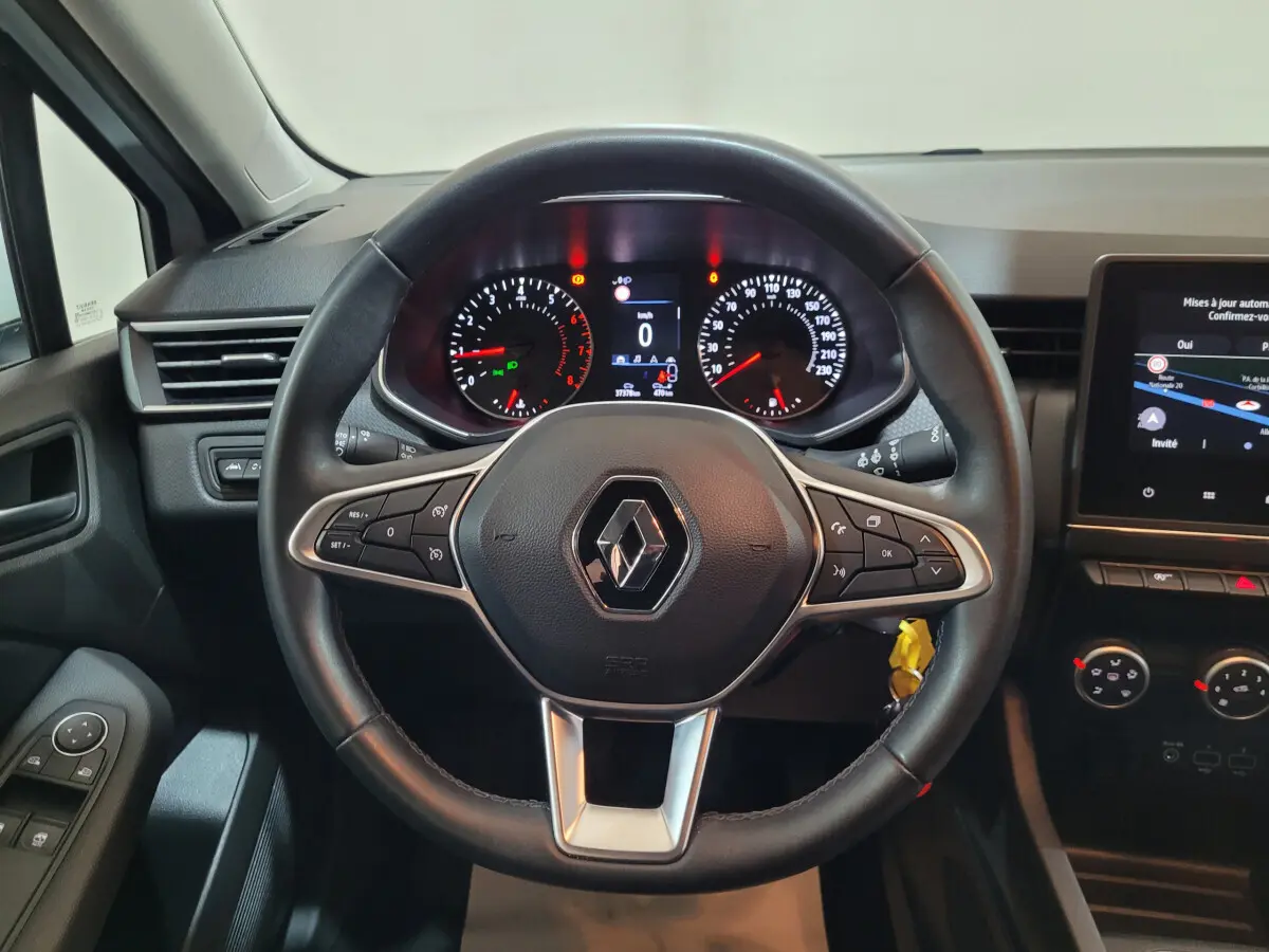 Vue intérieure centrée sur le volant cuir noir de la Renault Clio Business 2021 avec tableau de bord et écran tactile.